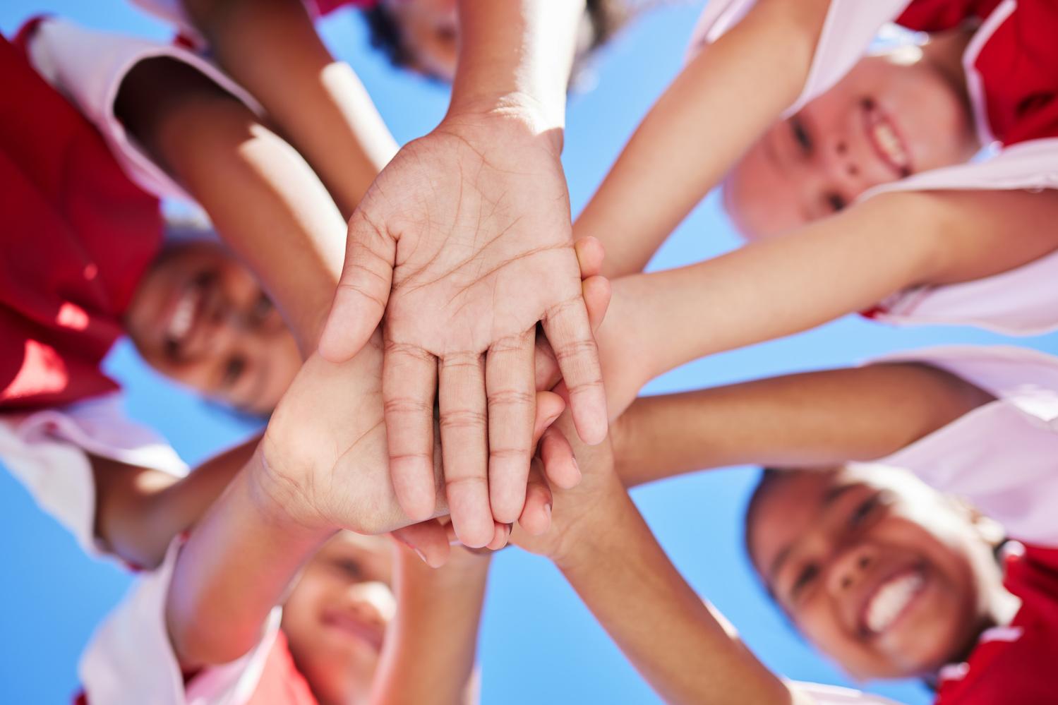kids putting hands in center - youth sports